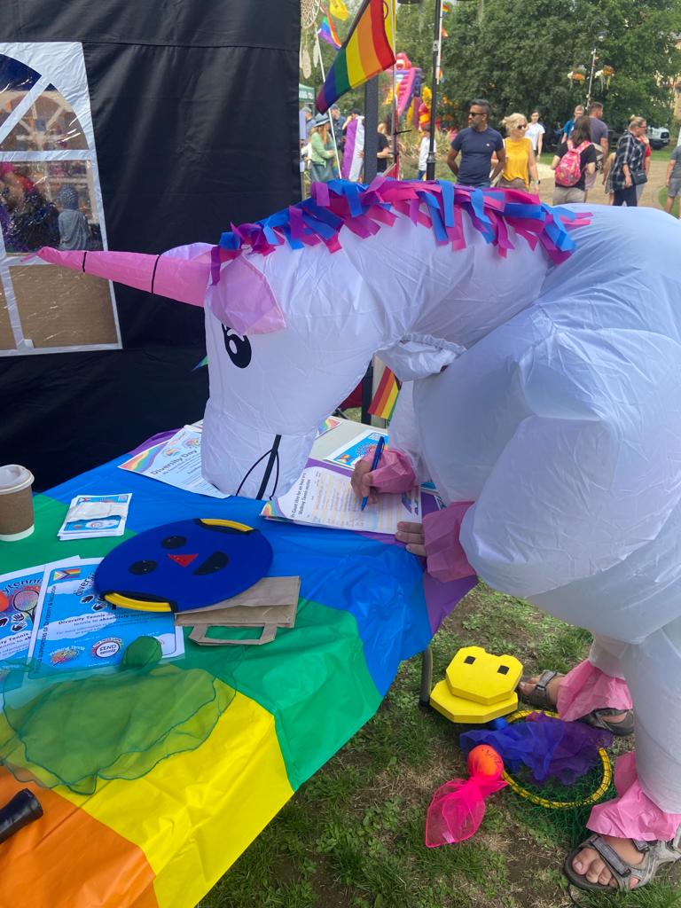 A man dressed as a unicorn signing up for our draw